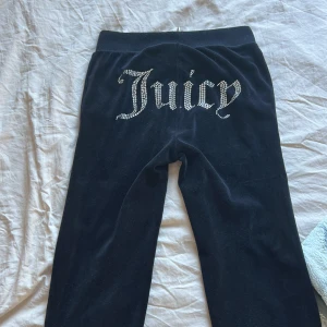 Svarta mjukisbyxor från Juicy Couture - Snygga svarta mjukisbyxor från Juicy Couture med glittrande text på baksidan och en liten logga framtill. Byxorna har en bekväm passform med snörning i midjan. Storlek XXS en av de främras metal bitt smörerna har gått av💗
