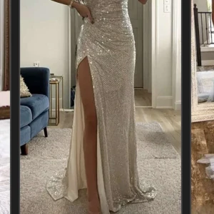 Glittrig långklänning med slits - Aldrig använd bara testad. Kom inte till användning då jag köpte en annan  Pris går att sänka något vid snabb smidig affär