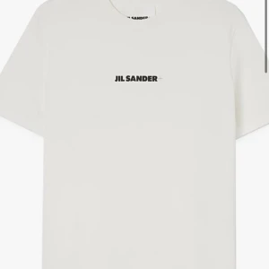 Vit t-shirt från Jil Sander - Snygg vit t-shirt från Jil Sander med enkel design och logga på bröstet. Perfekt för en stilren look. Helt ny med prislapp, nypris 3399kr