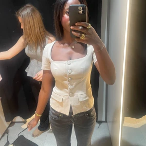 💕💕Säljer min super fina topp form Zara,perfekt för både fester och för vardagar💕💕 - Snygg vit blus med korta ärmar och knappar framtill. Den har en figurnära passform och en fyrkantig halsringning som ger en elegant touch. Perfekt för att klä upp eller ner beroende på tillfälle. Skriv om ni vill ha fler bilder 💕💕den är i Xs men passar perfekt på S har själv oftast S 