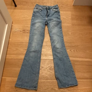 Blå bootcut jeans från Unique Denim - Snygga blå bootcut jeans från Unique Denim. De har en klassisk femficksdesign och en bekväm passform. Perfekta för en avslappnad stil med en touch av retro.