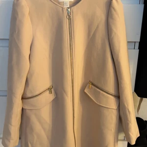 Beige kappa med dragkedja - Säljer denna fina kappa ifrån H&M i storlek 38, använt en gång men ser som ny ut🩷