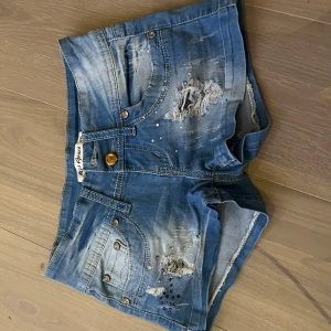Blå jeansshorts med slitningar - Snygga blå jeansshorts från Miss Anna med slitningar och nitar! Älskar dessa😍😍