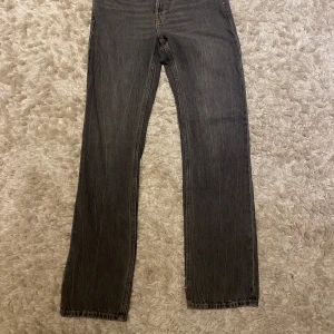 Grå jeans från Weekday - Snygga grå jeans från Weekday i en klassisk straight fit. De har en midwaist och är tillverkade i slitstarkt denim. Perfekta för en avslappnad stil.