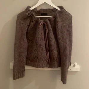 Lila stickad kofta från Bruuns Bazaar - Säljer en superfin lila stickad kofta från Bruuns Bazaar. Koftan har långa ärmar och en knytning framtill som ger en fin detalj. Perfekt för kyligare dagar. Koftan passar för både storlek XS och S