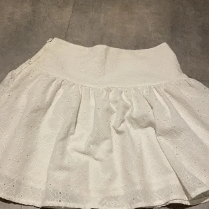 Vit somrig kjol från Koton x Rachel araz  - Charmig volang vit kjol från Koton x Rachel araz. med broderade detaljer. Köptes från koton vilket är ett väldigt populärt märke o Turkiet. Kjolen har en volangdesign och är perfekt för sommarens varma dagar. Den är tillverkad i ett lätt och luftigt material som ger en skön passform. 