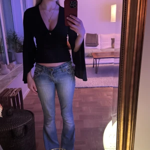 Svart långärmad topp med knyt - Snygg svart långärmad topp från gina med knytning framtill. Toppen har en v-ringad design och vida ärmar. 💕