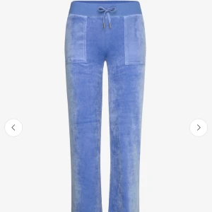 Juicy Couture byxor  - Snygga blåa juicy couture byxor i mjukt material med snörning i midjan. Byxorna har praktiska fickor både fram och bak med knappar. Perfekta för en avslappnad stil.