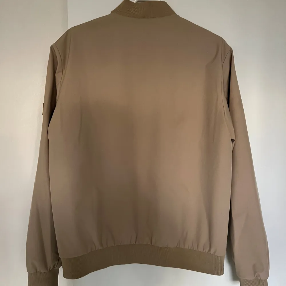 Snygg beige bomberjacka från Jack & Jones. Perfekt till våren då den är tillräckligt varm och vattentät. . Takit.