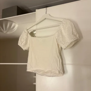 Vit blus med puffärmar - Charmig vit blus med puffiga kortärmar och broderade detaljer. Hör av er vid funderingar eller om ni vill ha bilder med hur plagget sitter på mig. Titta gärna in mina andra plagg!