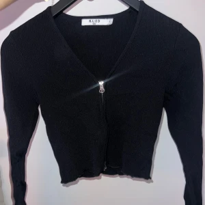 Svart ribbad tröja från NA-KD - Snygg svart ribbad tröja från NA-KD med dragkedja framtill. 