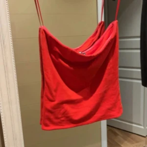 Röd topp från BikBok - Snygg röd topp från BikBok, dom banden som är på bilden är bara för man ska kunna hänga upp den om man vill. Så de är som en off shoulder topp