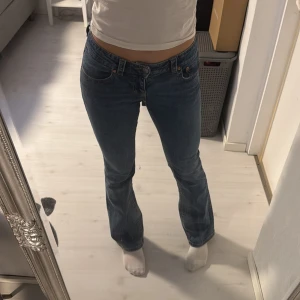 Blå bootcut jeans - Säljer dessa snygga blåa bootcut jeans från Ginatricot med knappar baktill. Kommer till användning ett fåtal gånger