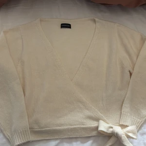 Beige omlottkofta från Even&Odd - Säljer en  beige omlottkofta från Even&Odd. Koftan har långa ärmar och en knytning i midjan för en snygg passform.