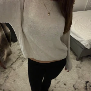 Vit stickad tröja - Säljer en vit stickad tröja med långa ärmar. Tröjan har en avslappnad passform och är perfekt för kyligare dagar. Den är mjuk och bekväm att bära.