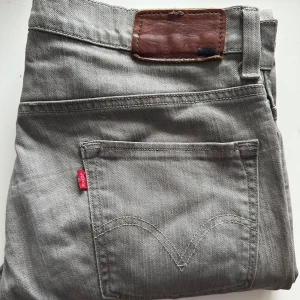 Grå jeans Levi's - Säljer dessa otroligt snygga jeansen från Levi’s! Modellen är 511 och skinny, men storleken gör så att den är mer avslappnad om man (som jag) brukar ha 31/32 i midjan i vanliga fall. Har en skada vid knappen, som inte syns om man har bälte eller en tröja över, men som såklart drar ner priset! 😁