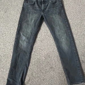 Grå jeans från Lee - Snygga grå jeans från Lee med en klassisk femficksdesign. De har en straight passform och är tillverkade i slitstarkt denim. Perfekta för en avslappnad stil.