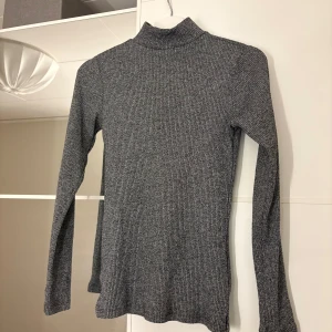 Grå ribbad polotröja - Snygg grå ribbad polotröja. Hör av er vid funderingar eller om ni vill ha bilder med hur plagget sitter på mig. Titta gärna in mina andra plagg!