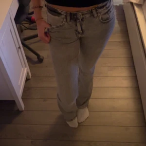 Grå bootcut jeans - Snygga grå jeans med bootcut passform och klassisk femficksdesign. Byxorna har låg midja och stängs med dragkedja och knapp. Perfekta till vardags för en avslappnad men stilren look.