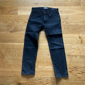 Svarta jeansbyxor från Dressmann - Säljer ett par svarta jeansbyxor från Dressmann med regular fit. Perfekta för dig som gillar en enkel och stilren look. De är i storlek 29-30. Säljer då de inte kommer till användning
