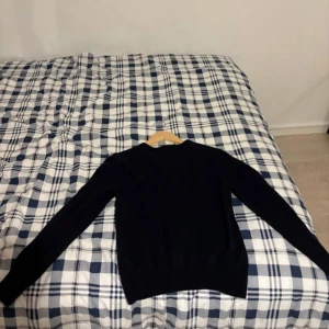 Svart stickad tröja från Tiger of Sweden - Säljer en svart stickad tröja från Tiger of Sweden. Tröjan har rund halsringning och långa ärmar. Perfekt för dig som gillar klassisk och stilren design.