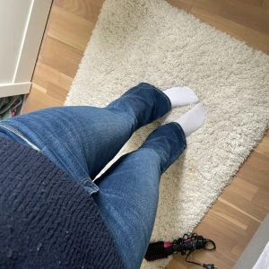 Blå bootcut jeans - Säljer ett par klassiska blå bootcut jeans med normal passform. Jeansen har fem fickor, dragkedja och knapp framtill. Perfekta för dig som gillar en tidlös stil med lite utsvängda ben.