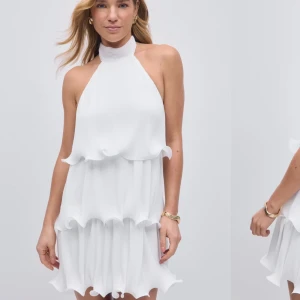 Vit halterneckklänning med volanger - Superfin vit kortklänning med halterneck och knyt i nacken. Klänningen har flera lager volanger som ger en lekfull och luftig känsla. Perfekt för sommarens alla tillfällen! Köpt för 599kr, säljer för 499kr