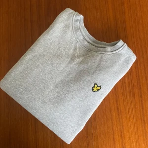 Grå Lyle scott sweatshirt  - Grå sweatshirt från Lyle & Scott. Perfekt för alla årstider. Perfekt för en stilren outfit. Skicket är 9/10