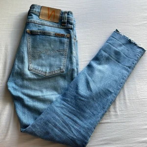 Ljusblå jeans från Nudie Jeans - Säljer ett par ljusblå jeans från Nudie jeans. Jeansen är i storlek W28 L32 och är använda ett fåtal gånger eftersom de inte passade mig. Nypris ligger på 1599. Hör av er om ni har frågor eller funderingar!