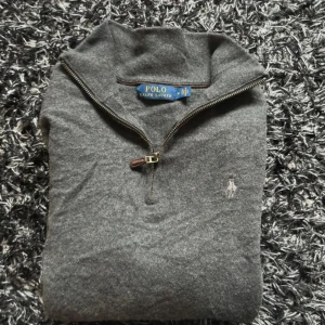 Grå halvzip tröja från Polo Ralph Lauren - En stilren grå quarterzip med utmärkt kvalitet! Varan är använd fåtal gånger och är i mycket bra skick. Storleken är märkt som M, själv så tycker jag att den sitter mer som S, (säljs eftersom den inte passar mig) Se måtten nedan för bäst passform! 📐Axelbredd 39 cm 📐Bröstvidd 44 cm 📐Längd 58 cm Nypriset ligger på runt 2200 kr, Hör av er vid minsta fråga! -Benjamin