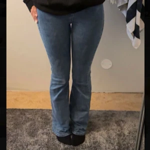 Blå bootcut jeans - Säljer ett par klassiska blå bootcut jeans i storleken tall. Jeansen har hög midja och är tillverkade i ett mjukt denimtyg. Jag är runt 180 i referens💞