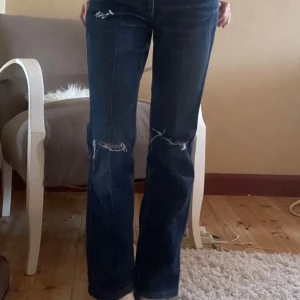  jeans med slitningar - Säljer ett par mörkblå Levis 501 jeans med snygga slitningar vid knäna. De har raka ben och är mid waist. 