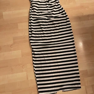 Svartvit randig tubklänning - Säljer en svartvit tajt tubklänning som har en slits bak. Perfekt för sommardagar! 