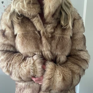 Nelly fejk pälsjacka - Säljer en fluffig och lyxig fejk beige pälsjacka från Nelly. Jackan har lång ärm och en klassisk rak passform. Perfekt för dig som vill sticka ut och hålla dig varm under kyliga dagar. Aldrig använd och köpt på plick!💗 Storlek 38