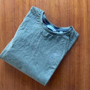 Olivgrön Gant T-shirt - Olivgrön T-shirt från Gant. Perfekt för en varm sommardag. Perfekt för en stilren outfit. Skicket är 9/10