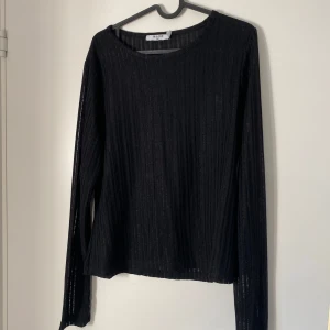 Svart ribbad långärmad tröja från NA-KD - Säljer en svart långärmad tröja från NA-KD i storlek XXL. Tröjan är ribbad och har en enkel, rak passform med rund halsringning. Perfekt att styla till olika outfits.