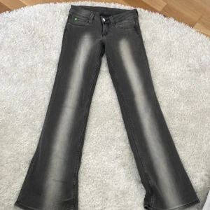 Grå bootcut jeans från weekday❤️ - Snygga grå jeans med bootcut passform och ljusa slitningar längs benen. Klassisk femficksmodell med knapp och dragkedja framtill. De är en storlek 28 på weekday. Vilket brujade passa mig som var en vanlig storlek 32/34. Använda 2-3 ggr❤️
