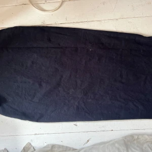 Svart långkjol i bomull - Säljer en enkel svart långkjol i mjukt bomullstyg. Kjolen har rak passform och är perfekt för dig som gillar en stilren och minimalistisk look. Passar till många olika outfits och är lätt att matcha.Väskigt strechig 