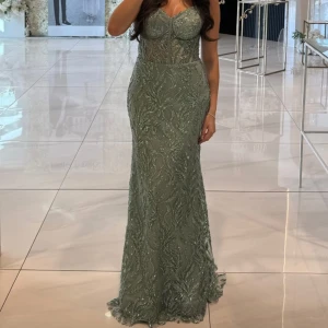 Grön/blå glittrig festklänning - Säljer en elegant grön/blå långklänning med glittriga detaljer. Perfekt för bal eller festliga tillfällen.