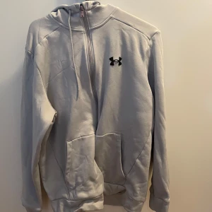 Under Armour hoodie - Tränings/tillvardags hoodie. Passar om man har mer av en sportswear/streetwear.                               Size:M                                                                                Cond: 6,5/10                                                                    Flaws: Dragdkedjan har blivit lite missfärgad.