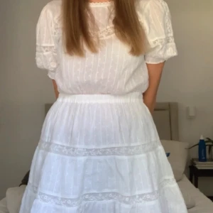 Vit klänning med spetsdetaljer från Zara - Superfin vit klänning från Zara med spetsinslag och diskreta broderier. Klänningen har korta puffärmar med resår och vacker struktur i tyget. Perfekt för sommarens alla tillfällen! 🎀🎀