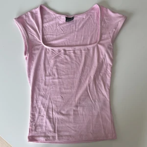 Ljusrosa linnetopp från Gina Tricot - Supersöt ljusrosa linnetopp från Gina Tricot med fyrkantig ringning och ärmlös design. Tunt och mjukt bomullsmaterial som känns skönt mot huden. Aldrig använd nypris 179kr.