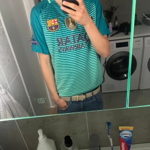 FC Barcelona Neymar Jr bortatröja - Säljer en FC Barcelona bortatröja från Nike med Neymar Jr och nummer 11 på ryggen. Tröjan är turkosblå med horisontella ränder och gula detaljer. Klassiska klubbmärken och sponsortryck på bröstet. Perfekt för dig som älskar Barca och Neymar. Pris kan diskuteras!