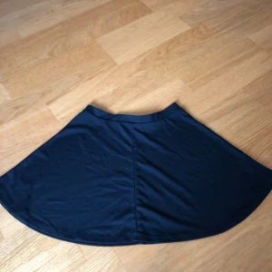 Svart kortkjol från Bik Bok - Enkel och snygg svart kortkjol från Bik Bok i mjukt bomullsmaterial. Kjolen har en lätt utställd form som ger en skön och avslappnad vibe. Perfekt att matcha med en crop top eller hoodie för en chill look.