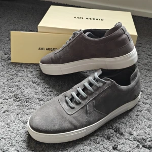 Axel Arigato mockasneakers - Oanvända platform sneakers från Axel Arigato i grå mocka med vita platta sulor. All tillbehör som låda, dustbag och extra skosnören ingår. Perfekta stilrena skor inför sommaren. Dessa är väl omhändertagna och endast använda en gång. Inga synliga spår av användning, endast lite under sulan. Vid frågor är det bara att kontakta. 🤝