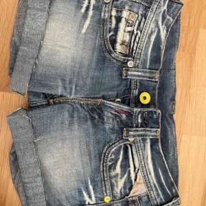 Replay jeansshorts med slitningar - JÄTTE låg midjade. Kan skicka bild på privat! Snygga blå jeansshorts från Replay. Perfekta för sommaren. Passar någon som har runt 32-36 i jeans. 