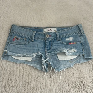 Hollister lågmidjade jeansshorts - Jättesnygg lågmidjade jeansshorts från Hollister! Midjemått ca 41 cm rakt över, grenhöjd ca 16 cm💘ett litet hål på en av bakre fickorna, men personligen tycker jag bara det ser ut som en del av designen. Har tyvärr inga bilder med de på då de är för stora för mig