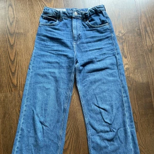 Blå raka jeans från Zara - Klassiska blå jeans från Zara i rak modell med normal passform. Jeansen har fem fickor, bälteshällor och stängs med knapp och dragkedja. Perfekta till en avslappnad stil och funkar året runt.