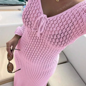 Lång rosa stickad klänning med snörning - Superfin långklänning i ljusrosa stickat material med v-ringning och snörning framtill.  Helt ny, aldrig använd.  Passar bra som bikini cover up också