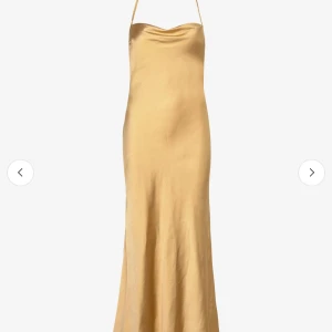 Gul långklänning i satinlook - Gul långklänning, något draperad urringning. Klänningen har en figurnära passform och skimrande satinliknande material. 